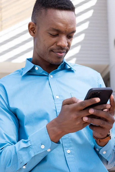 現代のオフィスの屋外でスマートフォンを使用して幸せなアフリカ系アメリカ人ビジネスマン グローバルビジネス オフィスのコンセプト — ストック写真