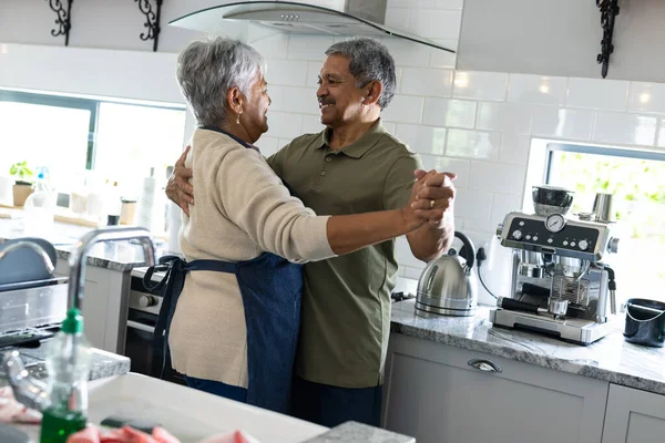 快乐的老夫妇手牵着手 在厨房跳舞时相互凝视着对方 复制空间 享受和生活方式的概念 — 图库照片