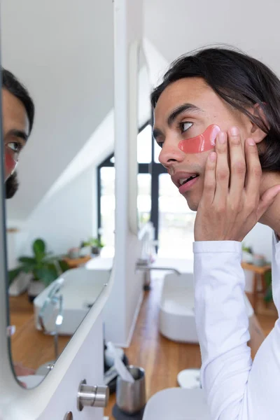 Feliz Hombre Birracial Mirándose Espejo Aplicando Parches Los Ojos Baño —  Fotos de Stock