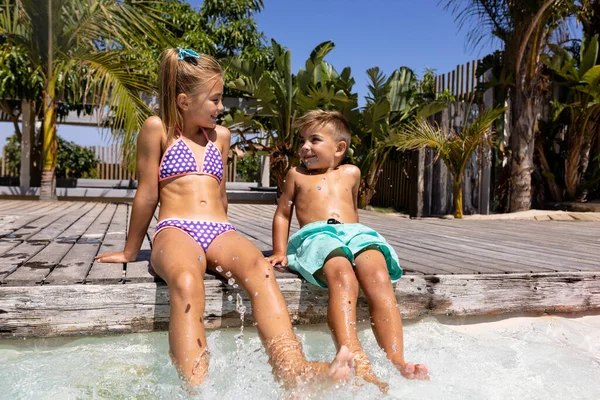 水泳プールのそばに座っている幸せな出産の弟と妹 質の高い時間 ライフスタイル 子供時代 休暇の概念を過ごす — ストック写真