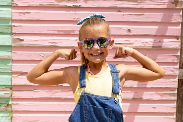 Портрет Счастливой Расы Девушки Улыбающейся Показывающей Мускулы Над Розовой Стеной — стоковое фото