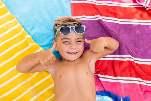 一个快乐的小孩笑着躺在游泳池边的毛巾上的画像 花费高质量的时间 生活方式 夏季和假期的概念 — 图库照片