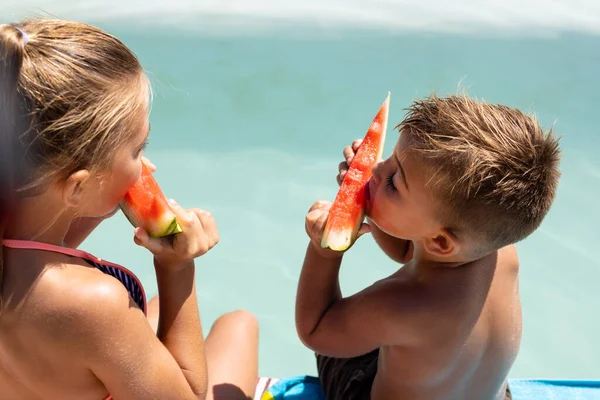 水泳プールでスイカを食べる幸せな実兄と妹 質の高い時間 ライフスタイル 子供時代 休暇の概念を過ごす — ストック写真