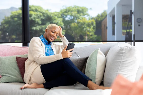 Mujer Afroamericana Feliz Usando Teléfono Inteligente Sentado Sofá Sala Estar — Foto de Stock