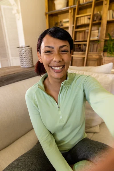 Mujer Birracial Feliz Haciendo Videollamada Con Dispositivo Mano Sonriendo Sala — Foto de Stock