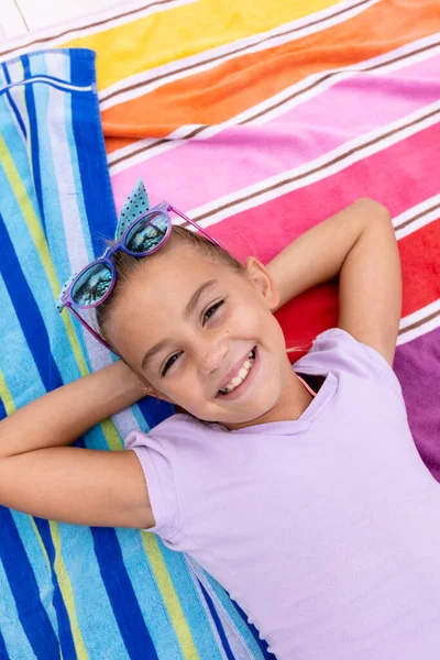 一个快乐的女孩微笑着躺在游泳池边的毛巾上的画像 花费高质量的时间 生活方式 夏季和假期的概念 — 图库照片