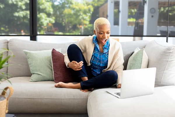 幸せなアフリカ系アメリカ人女性のラップトップを使用して リビングルームでソファに座っている 家庭だけで質の高い時間を過ごす 国内生活とライフスタイルの概念 — ストック写真