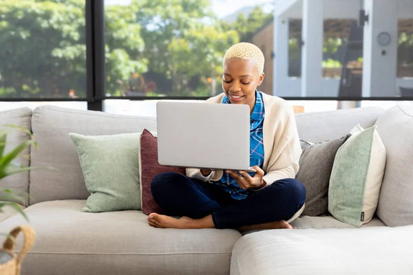 快乐的非洲裔美国女人使用笔记本电脑 坐在客厅的沙发上 独自待在家里的质量时间 家庭生活和生活方式概念 — 图库照片