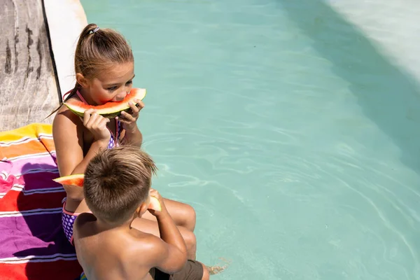 水泳プールでスイカを食べる幸せな実兄と妹 質の高い時間 ライフスタイル 子供時代 休暇の概念を過ごす — ストック写真