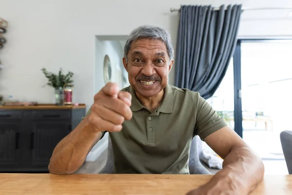 照片上 一位快乐的老人一边对着摄像机 一边对着餐桌边的视频交谈 生活方式 家庭和退休观念 — 图库照片