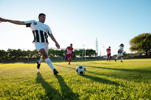 Jugador Multirracial Pateando Pelota Mientras Juega Partido Fútbol Contra Cielo — Foto de Stock