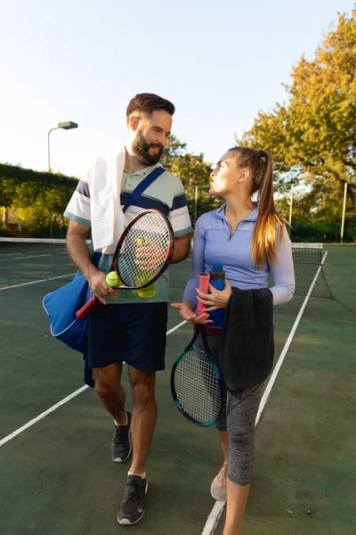 快乐的高加索夫妇在室外网球场上手握球拍和水瓶聊天 健康爱好 健身和闲暇时间概念 — 图库照片
