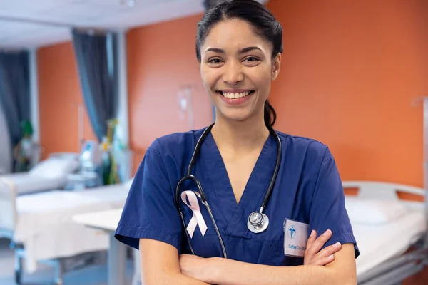 病院病棟 コピースペースで癌リボンを身に着けている笑顔の出産女性医師の肖像画 医療サービス — ストック写真