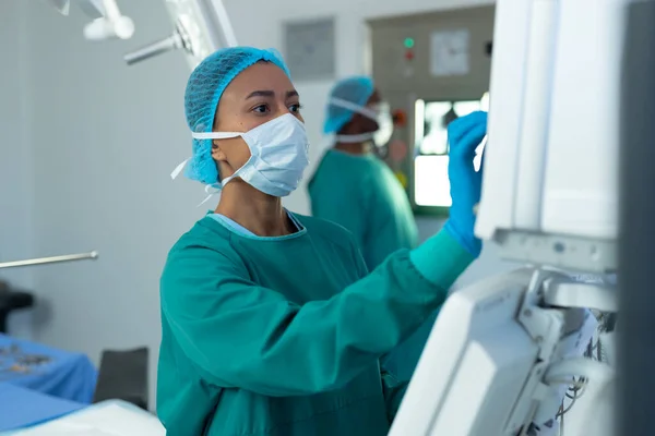Biraciale Vrouwelijke Chirurg Die Gecomputeriseerde Medische Apparatuur Operatiekamer Gebruikt Ziekenhuis — Stockfoto