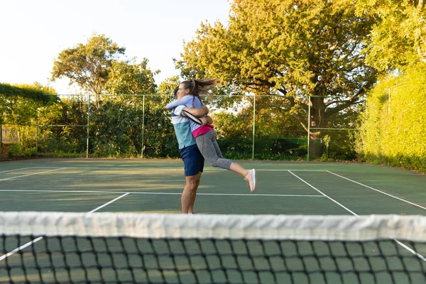 Happy Caucasian Couple Playing Tennis Embracing Outdoor Tennis Court Sport — Stock Photo, Image