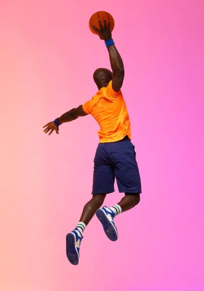 Imagen Jugador Baloncesto Afroamericano Saltando Con Baloncesto Sobre Fondo Rosa —  Fotos de Stock