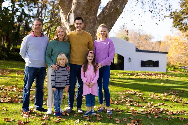 秋の庭でポーズをとっている幸せな多世代の白人家族のイメージ 家族と一緒に質の高い時間を過ごすコンセプト — ストック写真
