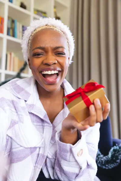 サンタの帽子をかぶった幸せなアフリカ系アメリカ人女性がビデオ通話をしています クリスマスだけで質の高い時間を過ごす — ストック写真
