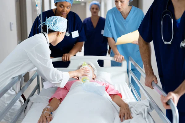 不同类别的医护人员在医院走廊为卧床病人提供呼吸机 医疗和保健服务 — 图库照片