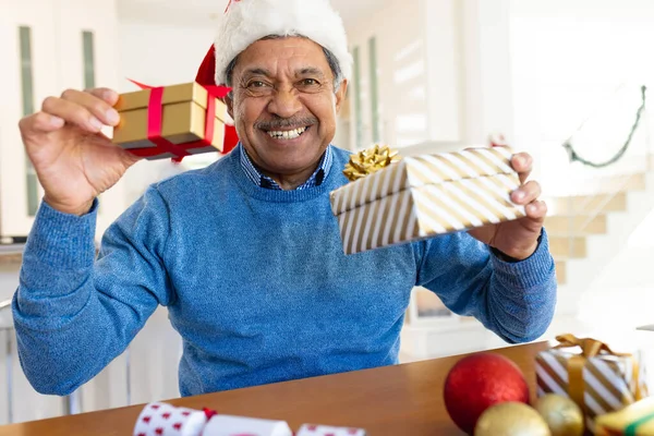 在视频通话中 戴着圣诞礼帽的快乐的长辈们拿着圣诞礼物 面带微笑 圣诞节 全球交流 包容性和老年生活方式概念 — 图库照片