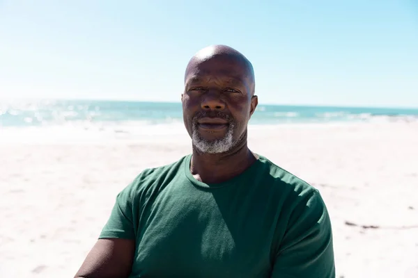 stock image Portrait of confident bald african american senior man standing at beach against sea and clear sky. Copy space, summer, unaltered, lifestyle, vacation, retirement, enjoyment and nature concept.