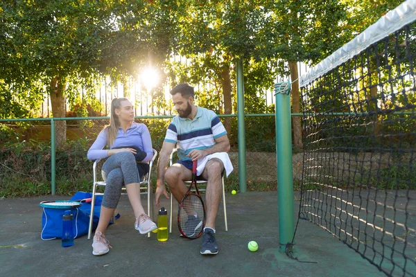 在室外网球场边的椅子上打网球的白种人夫妇坐在一起聊天 健康爱好 健身和闲暇时间概念 — 图库照片