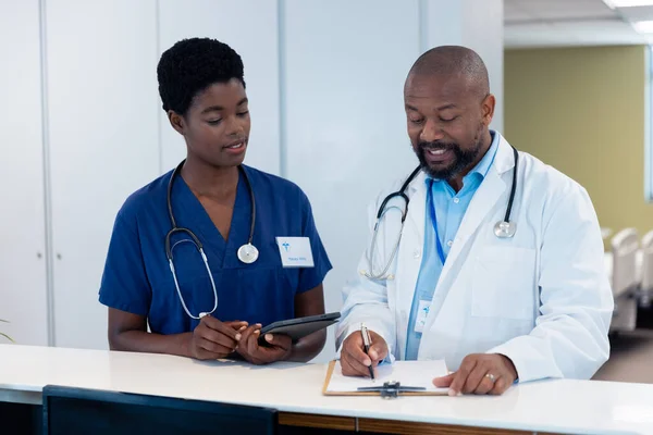 Afro Amerikaanse Mannelijke Vrouwelijke Arts Praten Schrijven Notities Ziekenhuisgang Ziekenhuis — Stockfoto