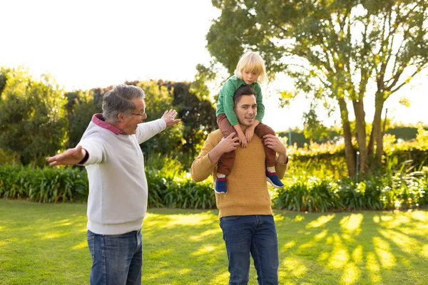 庭を歩く幸せな3世代の白人男性のイメージ 家族と一緒に質の高い時間を過ごすコンセプト — ストック写真
