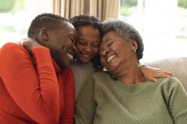 幸せなアフリカ系アメリカ人の3世代の女性がソファに座って抱擁のイメージ 家族と一緒に質の高い時間を過ごすコンセプト — ストック写真