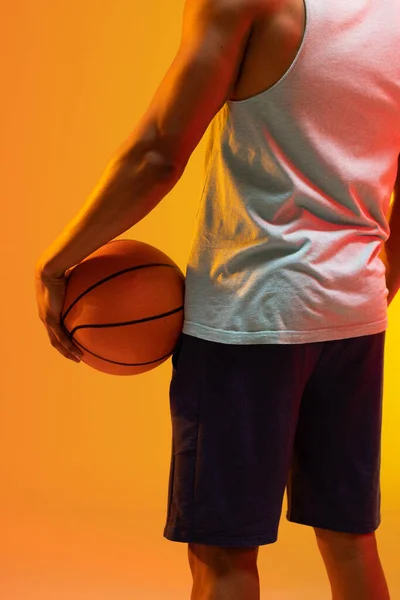 在橙色到黄色背景的篮球运动员的中段图像 体育和竞争概念 — 图库照片