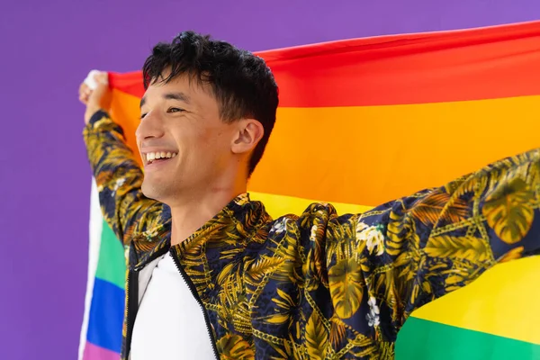 Glücklicher Mann Mit Lgbt Regenbogenfahne Und Lächeln Auf Lila Hintergrund — Stockfoto