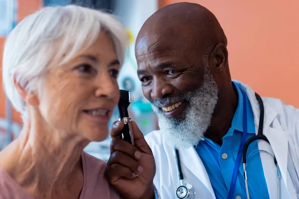 Sonriendo Diverso Médico Senior Masculino Usando Otoscopio Examinando Oído Paciente —  Fotos de Stock