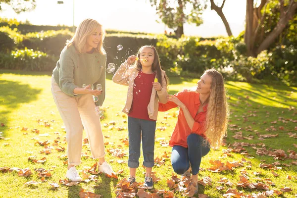 三代快乐的高加索女人在花园里带着肥皂泡的形象 家庭与共同度过美好时光的概念 — 图库照片