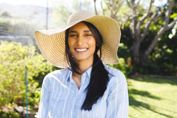 戴着太阳帽站在阳光灿烂的花园里笑着的快乐的桦树女子的画像 家庭生活和包容性概念 — 图库照片