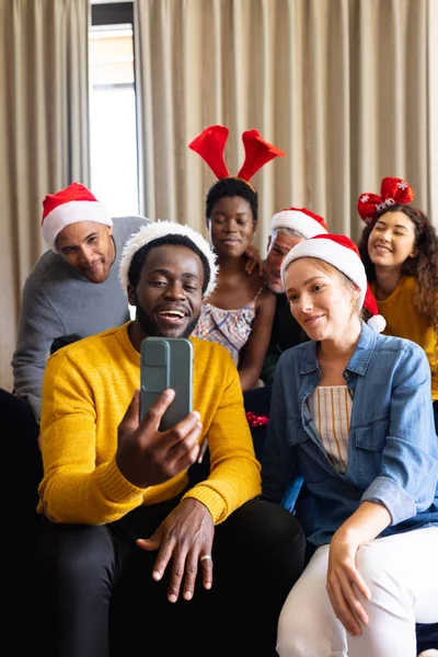 집에서 크리스마스를 축하하는 친구들의 이미지가 스마트폰으로 통화를 있습니다 크리스마스 포용성 — 스톡 사진