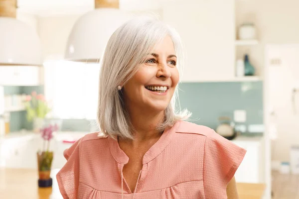 キッチンで笑顔の幸せなシニア白人女性 家庭や退職のコンセプトで質の高い時間を過ごす — ストック写真