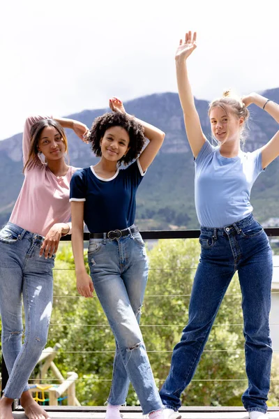 Image of three diverse women in t shirts with copyspace and denim trousers with nature background. Fashion, casual wear and nature concept.