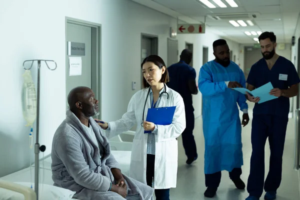 Ázsiai Doktornő Vigasztalja Vezető Afro Amerikai Férfi Beteget Kórházi Folyosón — Stock Fotó