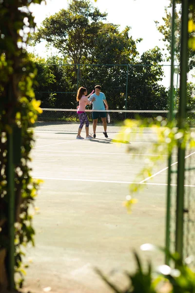 Smiling Biracial Couple Playing Tennis Embracing Sunny Outdoor Tennis Court — Stock Photo, Image