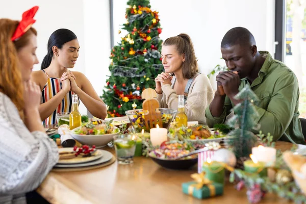Felices Amigos Diversos Sentados Mesa Rezando Antes Cena Navidad Navidad — Foto de Stock