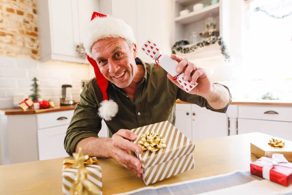 Homem Caucasiano Feliz Vestindo Chapéu Papai Noel Sentado Mesa Cozinha — Fotografia de Stock