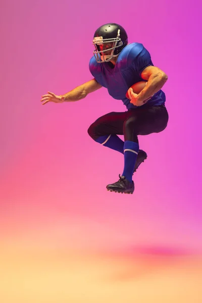 Biały Mężczyzna Amerykański Piłkarz Trzymający Piłkę Neonowym Różowym Oświetleniem Sport — Zdjęcie stockowe