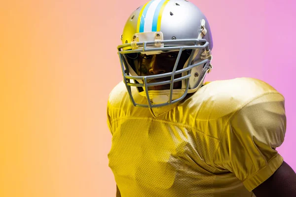 Africký Americký Fotbalista Nosí Helmu Neonově Žlutým Fialovým Osvětlením Sport — Stock fotografie