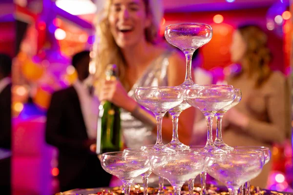 ナイトクラブのパーティーでシャンパンをグラスのピラミッドに注ぐ準備をしている幸せな白人女性 楽しい 外出し パーティーのコンセプト 選択的な焦点 — ストック写真