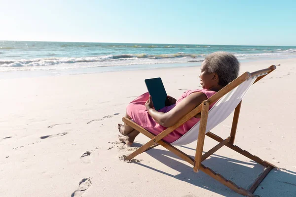 African American Senior Woman Using Digital Tablet While Relaxing Deckchair — Stock Photo, Image