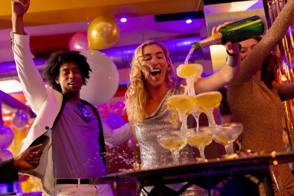 Счастливая Белая Женщина Наливающая Шампанское Бокалы Разнообразными Друзьями Ночном Клубе — стоковое фото