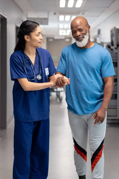 Vertical Diverse Female Doctor Helping Senior Male Patient Walk Corridor — Photo