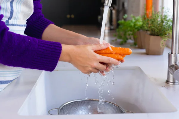 Środkowa Część Białej Kobiety Stojącej Kuchni Myjącej Marchewki Zlewie Życie — Zdjęcie stockowe