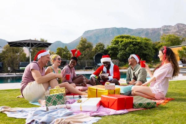 Felices Amigos Diversos Con Sombreros Santa Teniendo Picnic Jardín Navidad —  Fotos de Stock