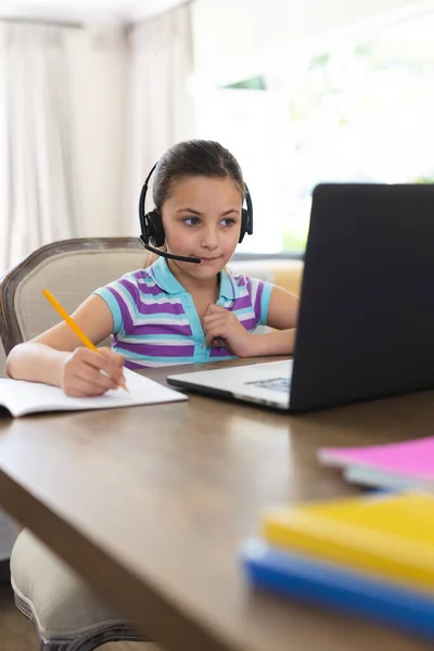 白人女孩在客厅学习和使用笔记本电脑和耳机 家庭教育 远距离教育 — 图库照片